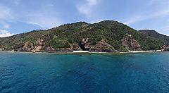 Costa dell'isola di Kerama con acqua cristallina e vegetazione rigogliosa.