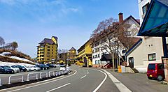 Edifici e strada a Kogen Onsen sotto un cielo sereno.