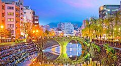 Ponte Meganebashi a Nagasaki illuminato al tramonto.