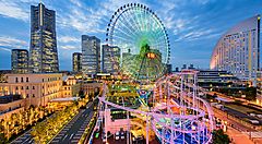 Ruota panoramica e grattacieli illuminati nel quartiere Minato Mirai di Yokohama.