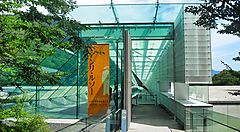 Ingresso moderno di un museo con struttura in vetro.