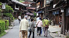 Persone che camminano lungo una strada tradizionale sul Nakasendo in Giappone.