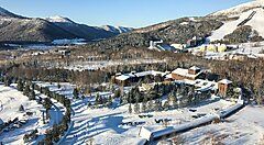Paesaggio innevato a Niseko con montagne e strutture invernali.