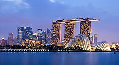 Skyline di Singapore al tramonto con Marina Bay Sands illuminato.