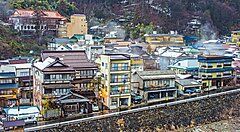 Veduta panoramica di Shibu Onsen con edifici tradizionali e fumi termali.