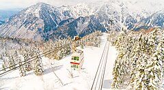 Funivia Shinhotaka tra montagne innevate e foresta.