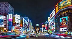 Strada illuminata di Susukino a Sapporo, con vivaci insegne al neon.