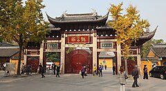 Ingresso del Tempio Longhua a Shanghai con alberi gialli.