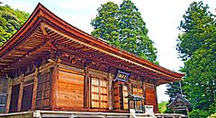 Tempio Onsenji in legno circondato da alberi verdi.