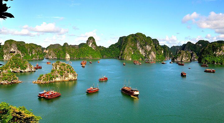 Baie di Halong in Vietnam con barche e formazioni rocciose.