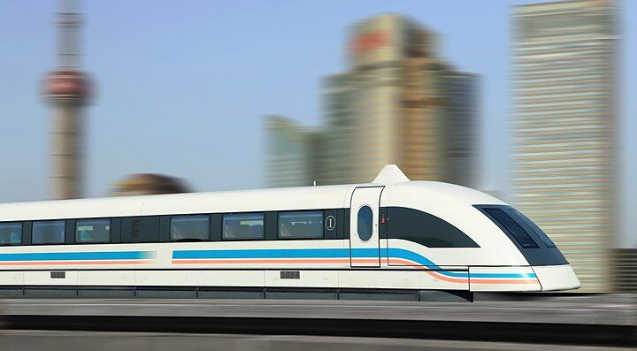 Treno ad alta velocità a Shanghai con grattacieli sullo sfondo.