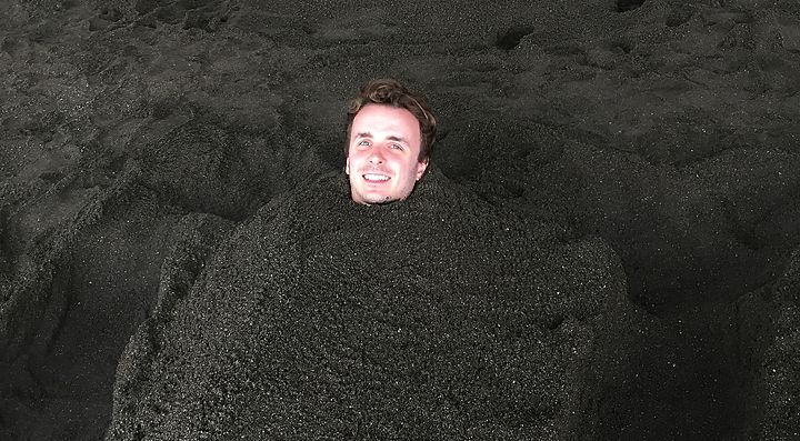Marco Togni immerso in un bagno di sabbia a Beppu.