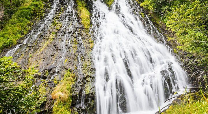 Cascata Oshinkoshin circondata dalla vegetazione verde rigogliosa.