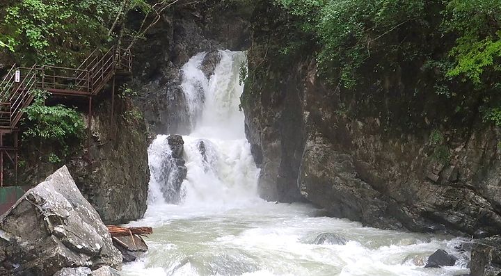 Cascata circondata da rocce e vegetazione a Hida.