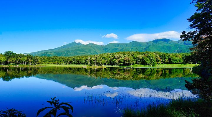 Paesaggio dei cinque laghi di Shiretoko con montagne riflesse nell'acqua.