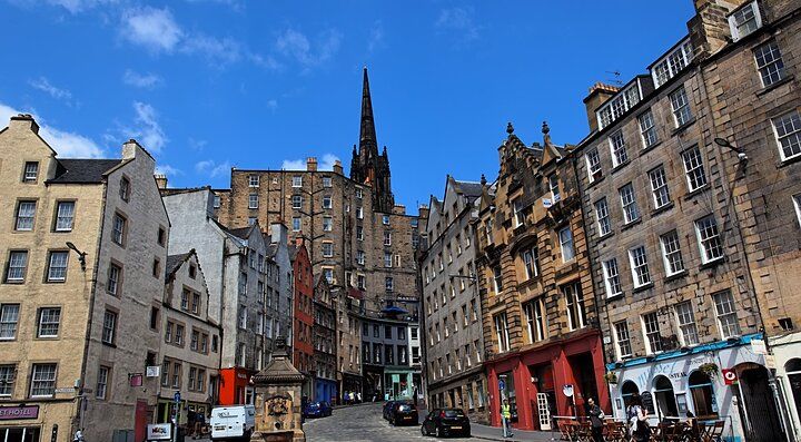 Una strada storica di Edimburgo con edifici classici e un cielo blu.