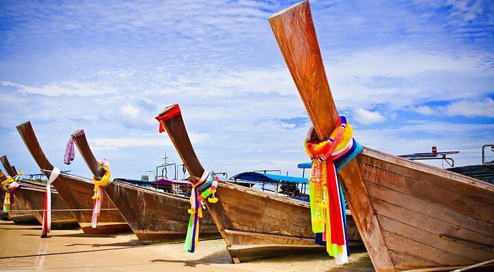 Barche tradizionali tailandesi decorate ormeggiate sulla spiaggia di Krabi.