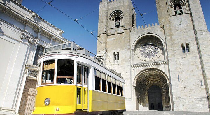 Tram giallo di fronte alla Cattedrale di Lisbona.