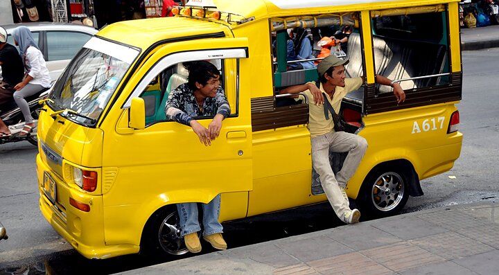 Minibus giallo con passeggeri a Phuket, Thailandia.