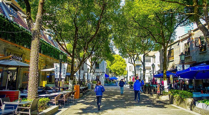 Strada alberata nella concessione francese di Shanghai con persone che passeggiano.