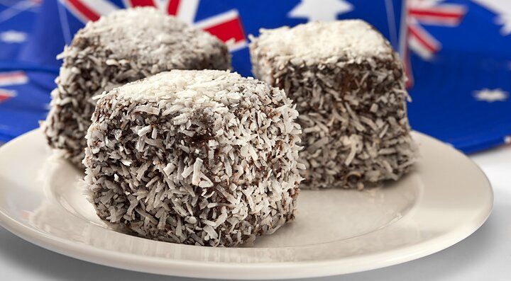 Dolci Lamington australiani su un piatto con sfondo della bandiera australiana.