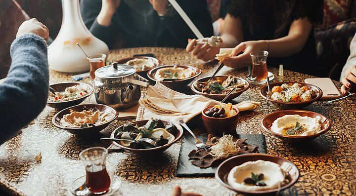 Piatti di cucina libanese su un tavolo con persone che cenano.
