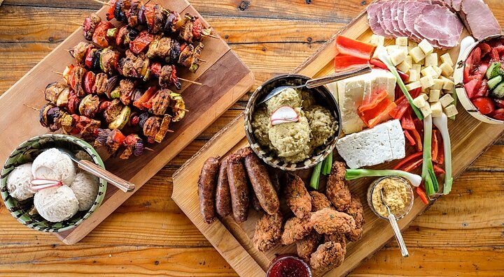 Piatti tradizionali rumeni su tavole di legno, tra carne, formaggi e verdure, su un tavolo rustico.