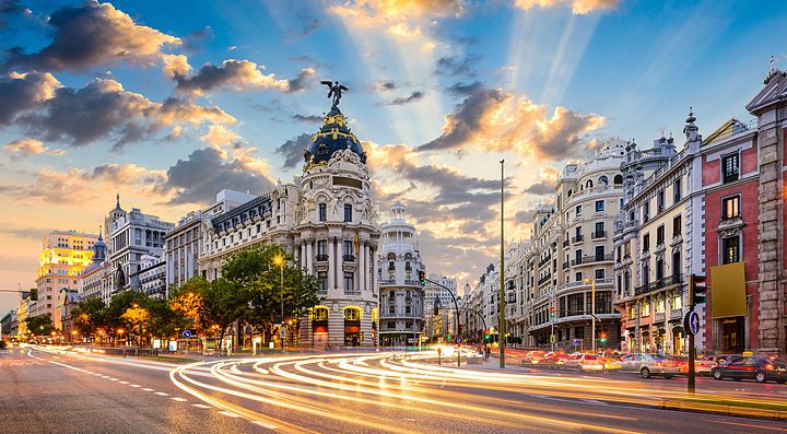 Gran Via a Madrid al tramonto con edifici storici.