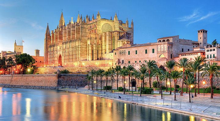 La cattedrale di Palma a Maiorca riflessa sul mare al tramonto.
