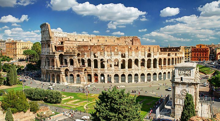 Il Colosseo a Roma con cielo azzurro e nuvole.