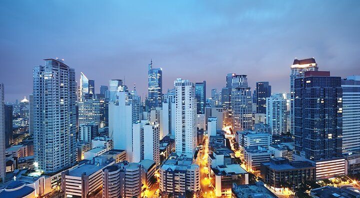 Skyline serale di Manila illuminata con edifici moderni.