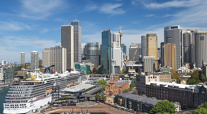 Skyline di Sydney con edifici moderni e una nave da crociera.