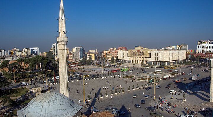 Piazza centrale di Tirana con minareto e edifici circostanti.