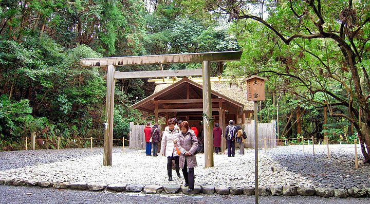 Un santuario tradizionale giapponese circondato da alberi e visitatori.