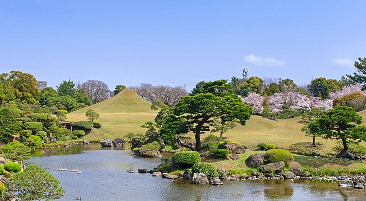 Giardino Suizenji in Giappone con un laghetto e alberi ben curati.