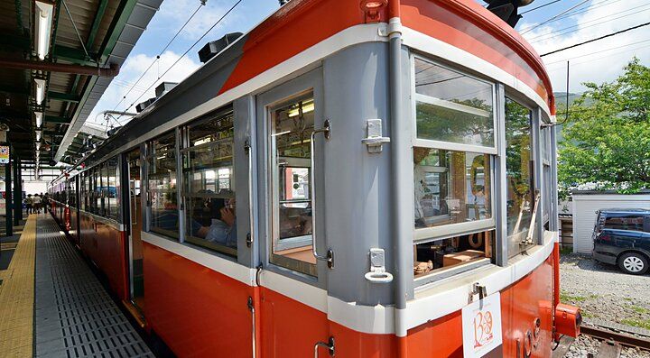 Il treno rosso della Ferrovia Hakone Tozan fermo in stazione.