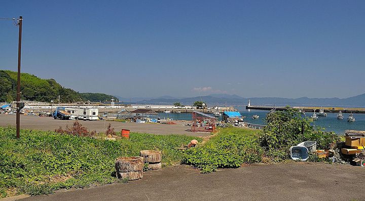 Porto sull'isola di Tashiro con barche, vegetazione e cielo sereno.