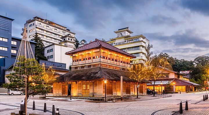 Edifici tradizionali giapponesi illuminati a Kaga Onsen al crepuscolo.