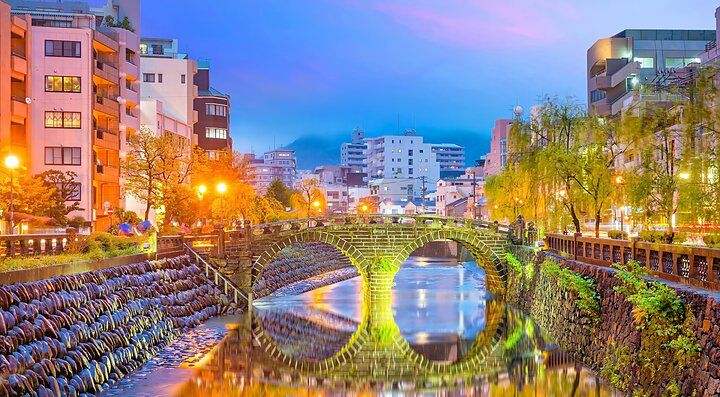 Ponte Meganebashi a Nagasaki illuminato al tramonto.