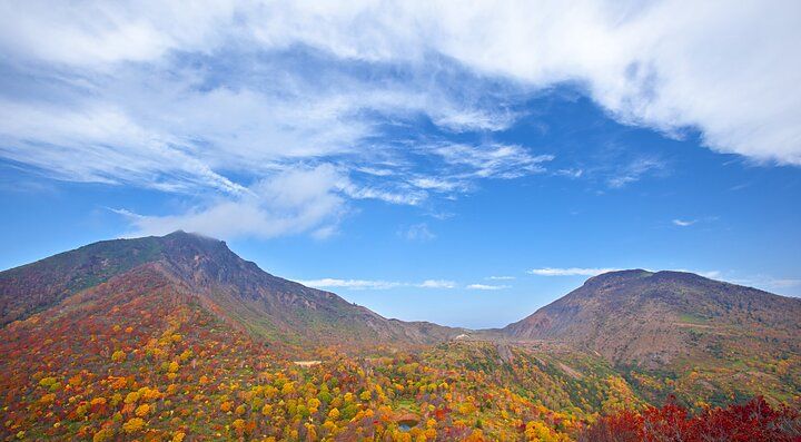 Il Monte Bandai con paesaggio autunnale e cielo azzurro.