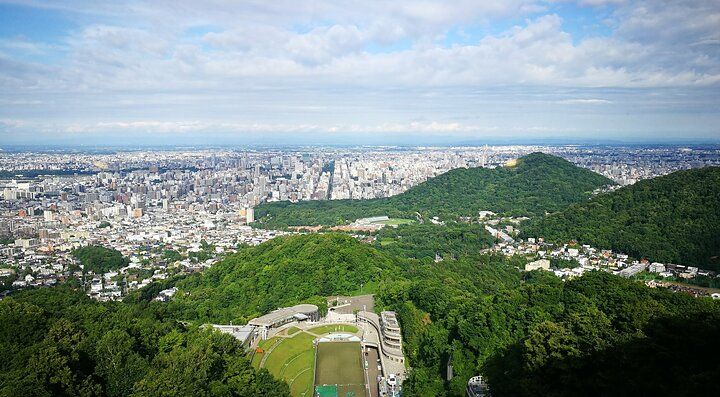 Veduta panoramica dal Monte Moiwa con città e colline verdi.