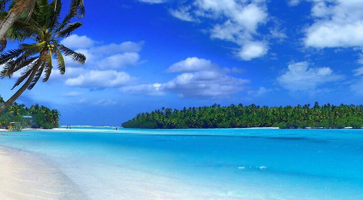 Spiaggia tropicale con palme e acque turchesi in Nuova Caledonia.