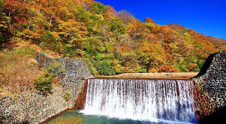 Cascata tra colline autunnali a Nyuto Onsen in Giappone.