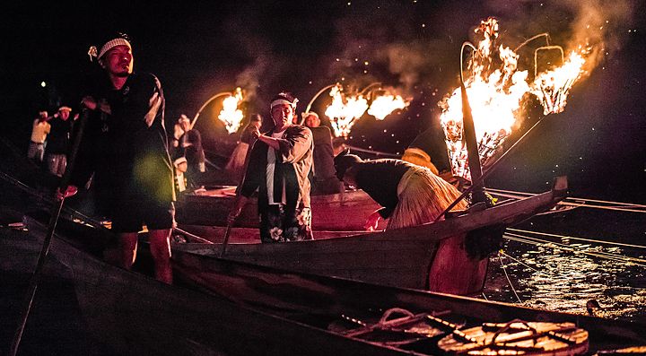 Pesca tradizionale notturna con cormorani a Gifu, illuminata da torce.
