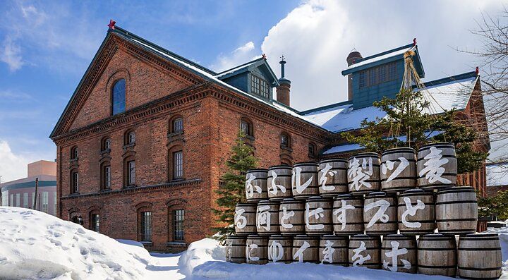 Museo della birra di Sapporo con barili di legno e neve circostante.