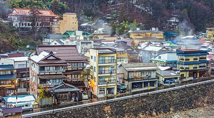 Veduta panoramica di Shibu Onsen con edifici tradizionali e fumi termali.
