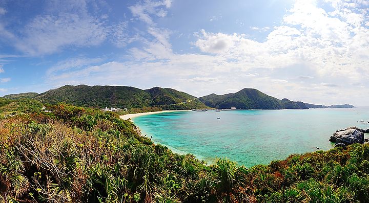 Costa di Okinawa con mare azzurro e cielo parzialmente nuvoloso.