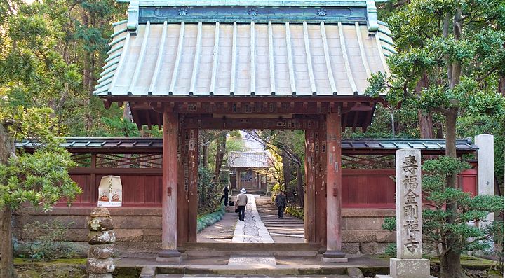 Ingresso del tempio Jufuku-ji circondato da alberi verdi.