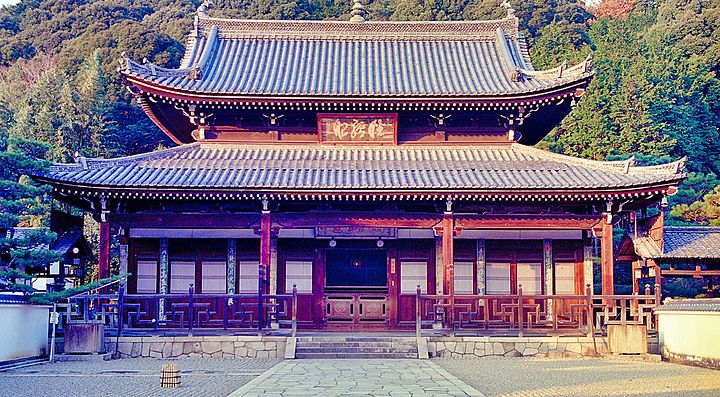 Tempio Mampukuji in legno con tetto tradizionale circondato dalla natura.