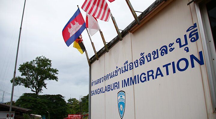 "Ufficio immigrazione a Sangkhlaburi con bandiere sventolanti"
